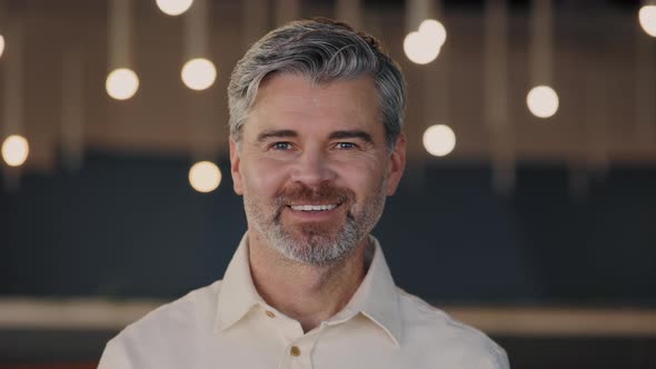 Successful Aged Man in Formal Outfit Turning Head and Looking at Camera While Standing at the Office alt