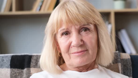 Portrait of a Beautiful Old Retired Woman She is Looking Carefully Into the Camera Lens and Smiling alt