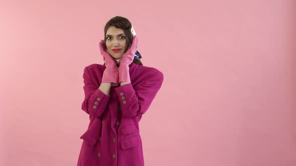 A Woman with Bright Makeup in Rubber Gloves is Surprised and Looks at the Camera