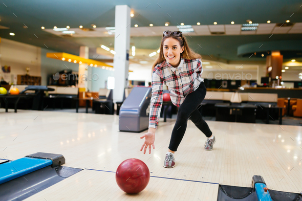 Focused happy woman enjoying bowling