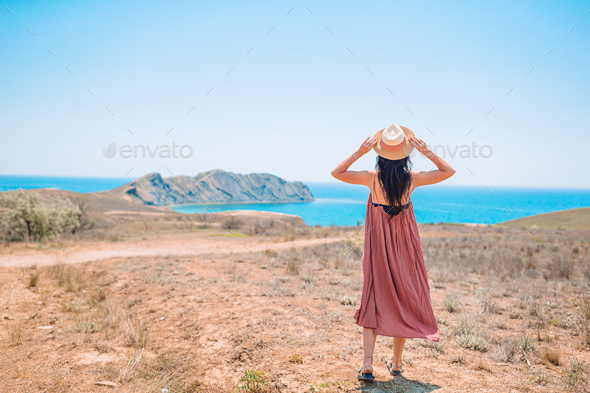Tourist woman outdoor on edge of cliff seashore