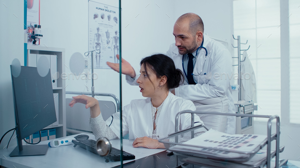 Medical staff examining scan on PC - Stock Photo - Images