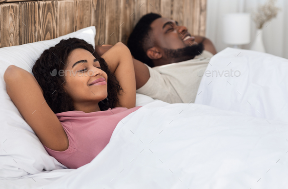 Relaxed african couple enjoying their new bed