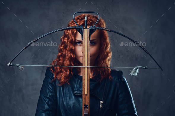 Redhead female holds crossbow.