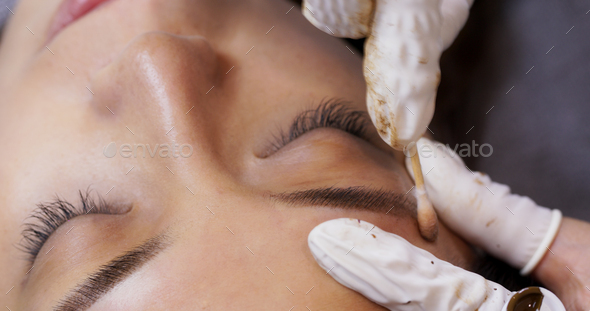 Beautician specialist of permanent makeup making brow microblading tattooing make up
