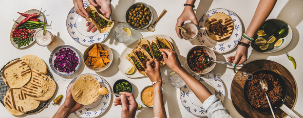 Family or friends having Mexican style Taco dinner with beer - Stock Photo - Images