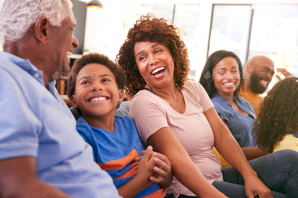 Multi-Generation African American Family Relaxing At Home Sitting On Sofa Watching TV Together
