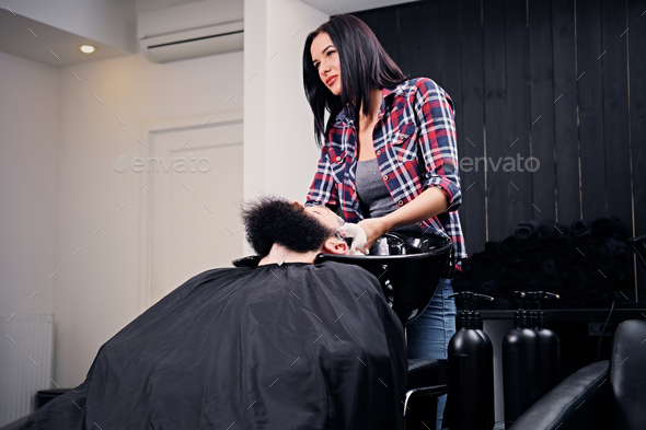 Hairdresser washing the hair of the bearded men.