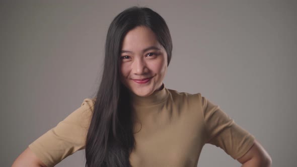 Confident asian woman happy standing smilling and looking at camera standing over background.