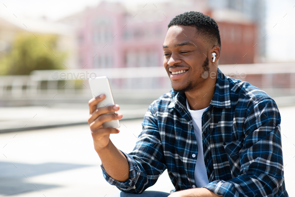 Portrait of african american guy watching video on cell phone