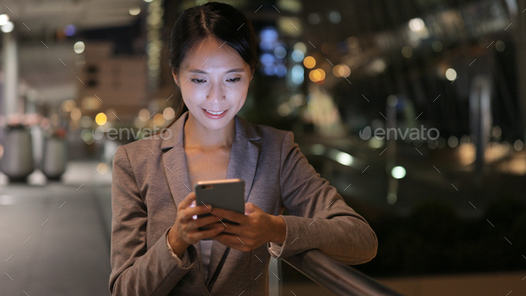 Business woman use of mobile phone at night