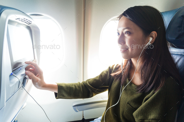 Woman watching movie on entertainment on plane
