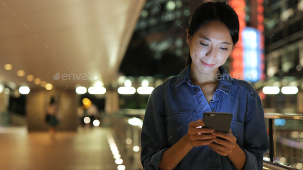 Chinese woman using smart phone at night