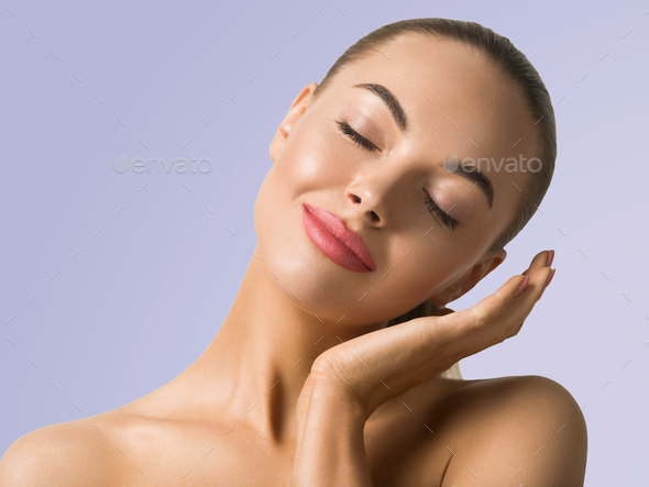 Clean skin woman face close up skin beauty tanned face beautiful smile over blue background