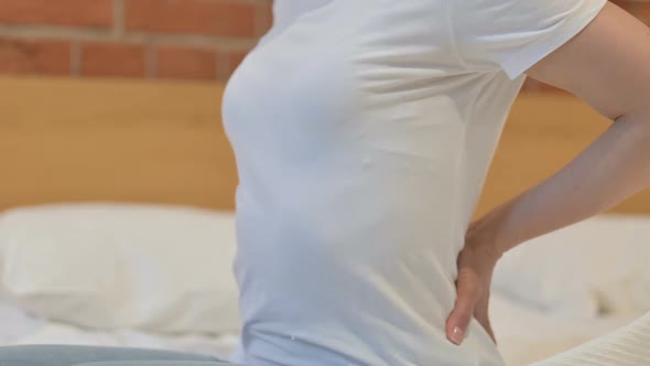 Close up of Young Indian Woman having Back Pain in Bed alt