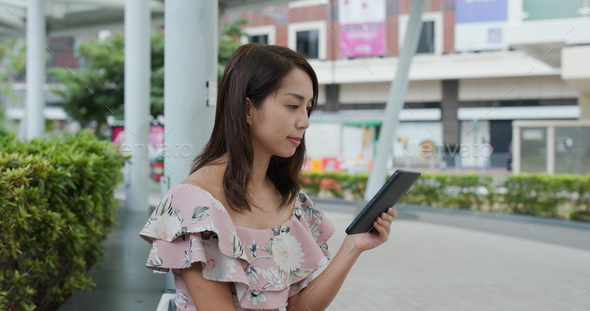 Woman read book on electronic reader at outdoor