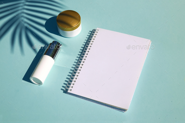 Cosmetic natural products on pastel blue background. Notebook for inscription - Stock Photo - Images