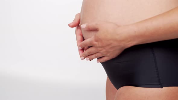 Young, happy and healthy pregnant woman in front of white background. alt