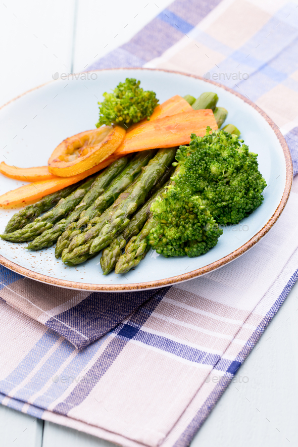Fried asparagus with broccoli and lemon and carrot.