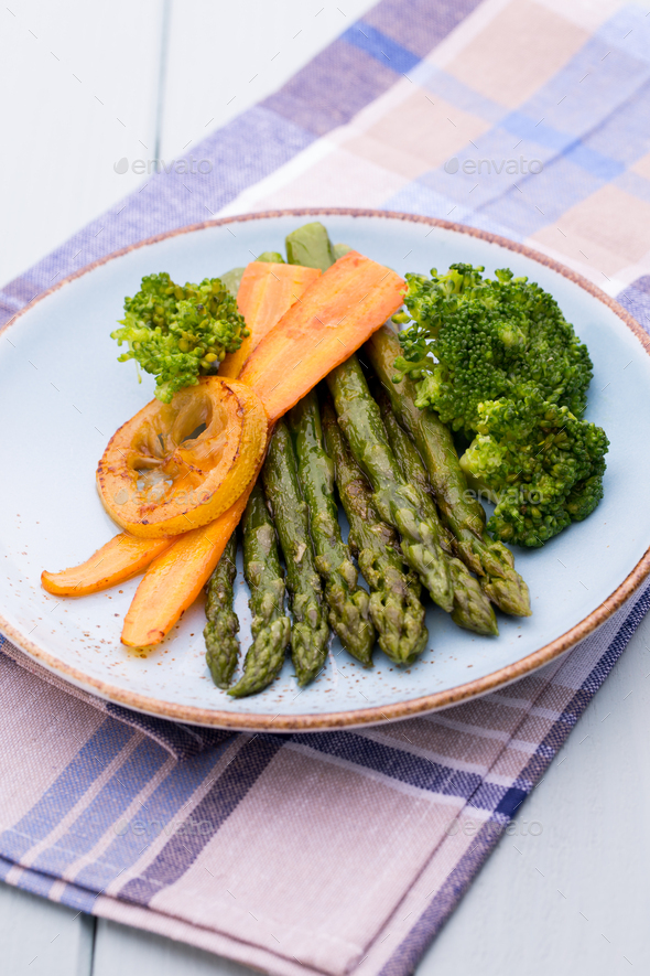 Fried asparagus with broccoli and lemon and carrot.