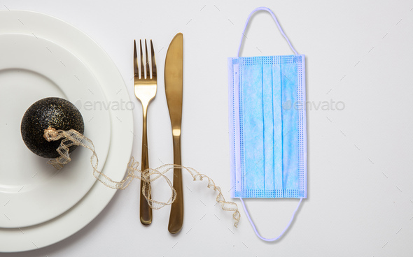 Coronavirus Covid19 christmas table concept, festive place setting with face mask - Stock Photo - Images