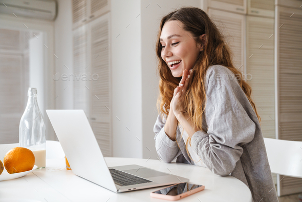 Portrait of excited woman expressing surprise while working with laptop