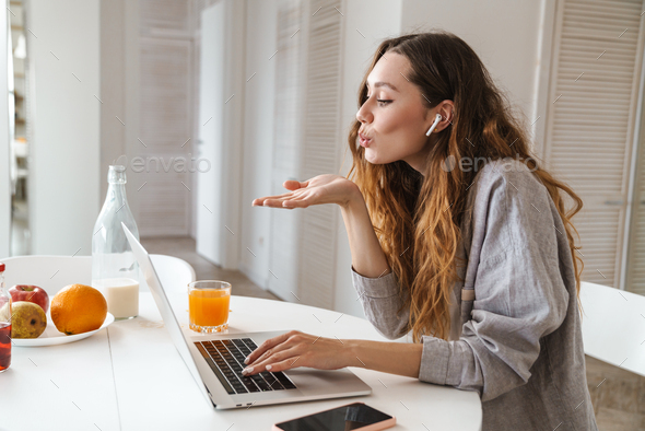 Portrait of woman blowing air kiss while making video call on laptop