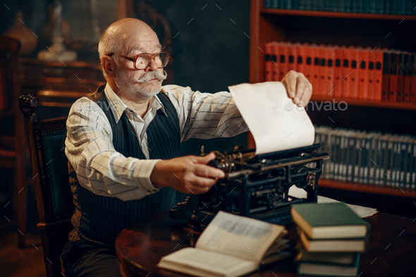 Elderly writer inserts paper into the typewriter