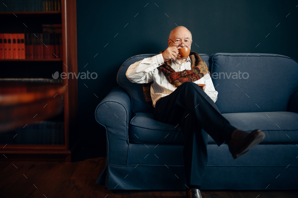 Elderly writer drinks coffee in home office - Stock Photo - Images