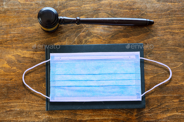 Protective mask and judge gavel on wooden office desk background, law - Stock Photo - Images