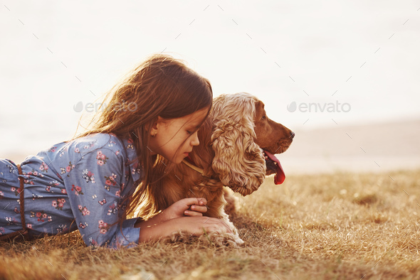 Warm and quiet. Cute little girl have a walk with her dog outdoors at sunny day