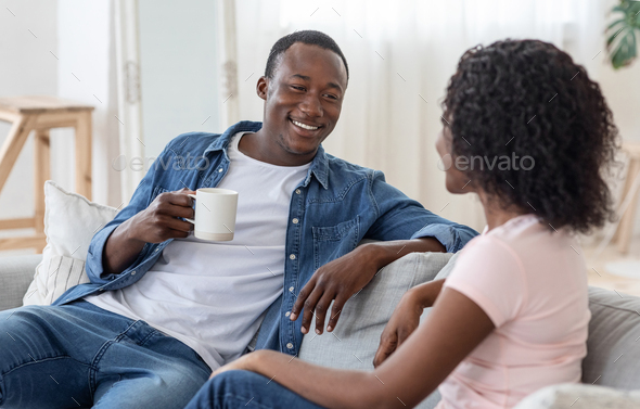 Lovely african couple drinking tea and having conversation