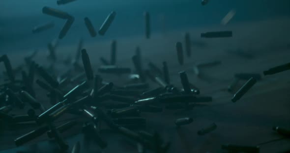 Lots of Bullets falling Down on water ground. War Concept. Professional Cinematic Slow Motion alt