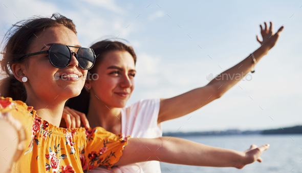 Selfie of two smiling girls outdoors that have a good weekend together at sunny day