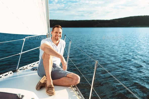 Joyful Man Sitting On Yacht Boat Deck Sailing Across Sea