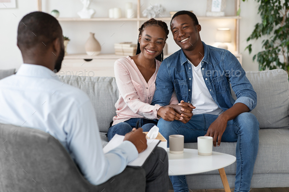 Effective Marital Therapy. Happy african couple sitting on couch at counselor's office