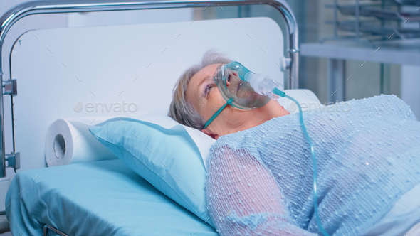 Retired old woman breathing with oxygen mask