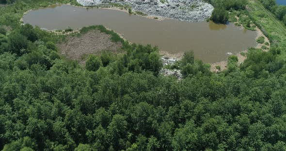 Aerial Top View of Illegal Garbage Dump in the Middle of the Green Forest alt