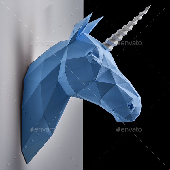 Blue unicorn\'s head hanging on the contrast white and black wall