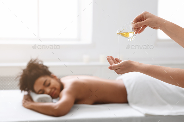 Massage Therapist Pouring Oil On Her Hands Before Procedure Stock Photo