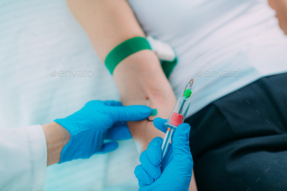 Medical worker with PPE taking blood sample from patient in a hospital ...