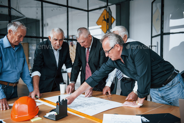 Aged team of elderly businessman architects have a meeting in the office