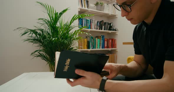 Christian Religious Man Prays and Reads Holy Bible at Home Studying Scripture alt