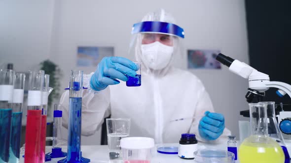 Exploring New Coronavirus in Laboratory Virologist is Viewing Liquid in Vial alt