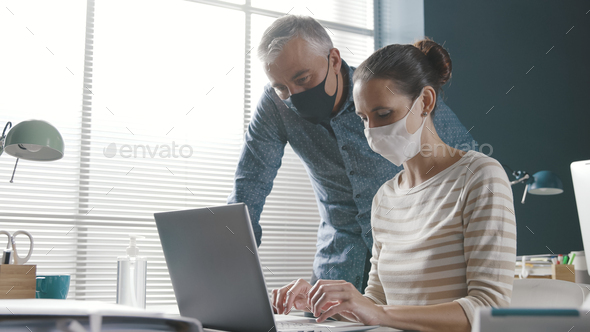 Business people working together in the office and wearing face masks