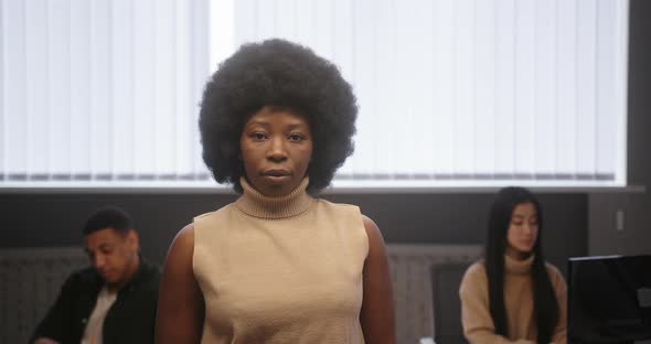 African American Woman with Crossed Arms Looks at Camera