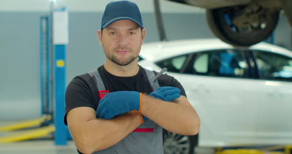 Portrait of a Car Mechanic at Work at the Car Repair Shop, Smiling Man at Factory Warehouse. alt