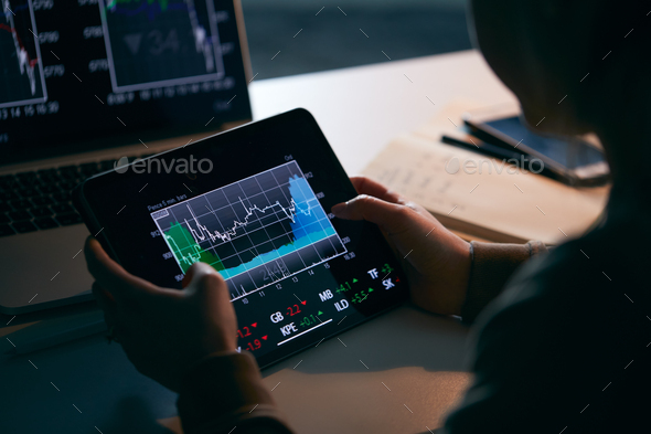 Close Up Of Female Share Trader At Desk With Stock Price Data Displayed On Laptop And Digital Tablet - Stock Photo - Images
