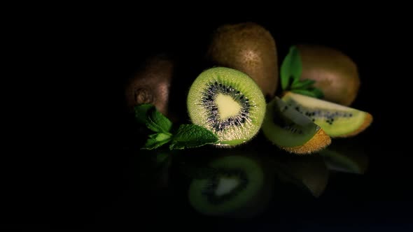 Kiwi Fruits Lie on a Table on a Black Background alt