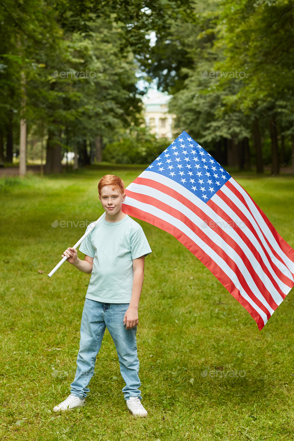 Red Haired Teenage Boy Holding American Flag Outdoors
